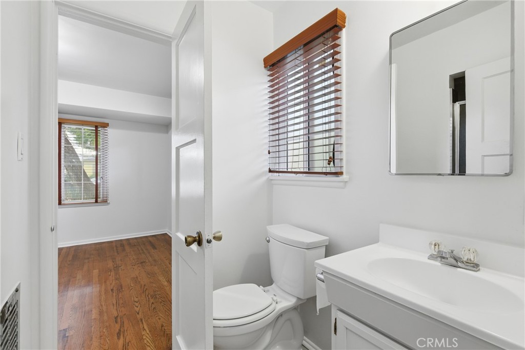 16753 Magnolia Boulevard Encino, CA 91436 - Photo 16 of 30 a bathroom with a toilet a sink and mirror