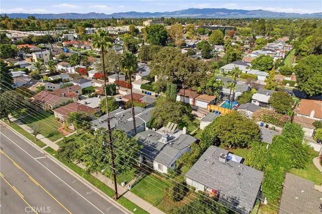 an aerial view of residential houses with outdoor space and street view