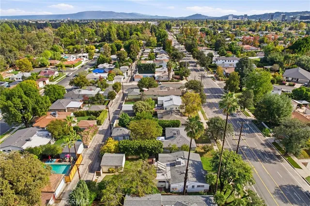 an aerial view of residential building with outdoor space and trees
