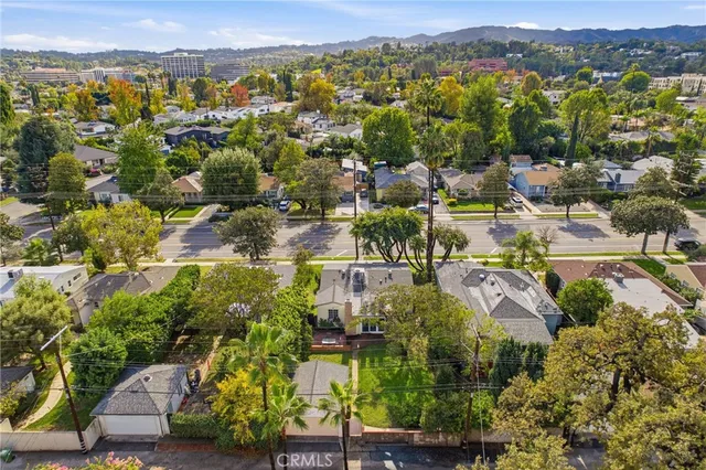 an aerial view of residential houses with outdoor space and trees