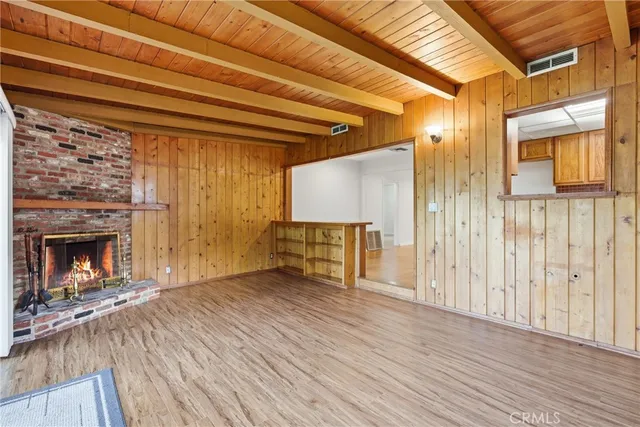 a view of a livingroom with wooden floor and a fireplace