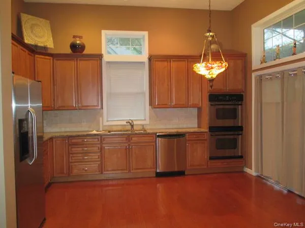 a kitchen with stainless steel appliances granite countertop a refrigerator and a sink