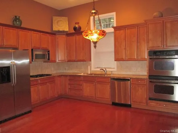 a kitchen with stainless steel appliances granite countertop a refrigerator a sink dishwasher with a stove and oven