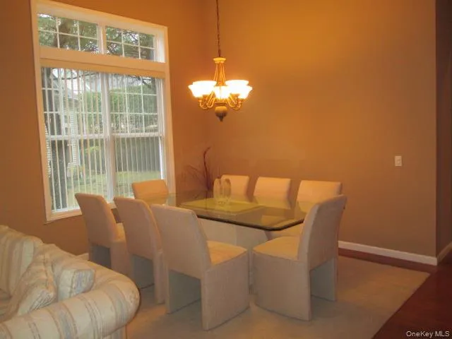 a view of a dining room with furniture and a chandelier