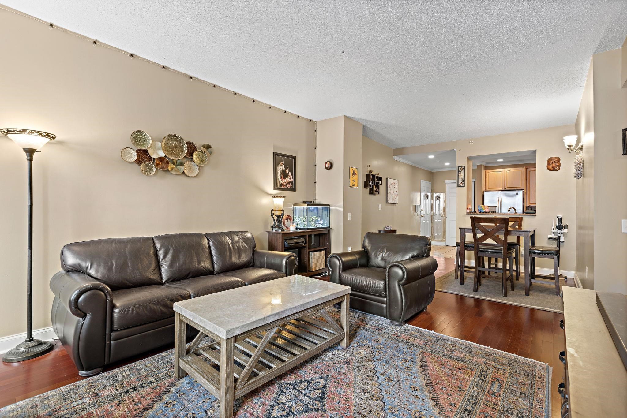 a living room with furniture a wooden floor and chandelier