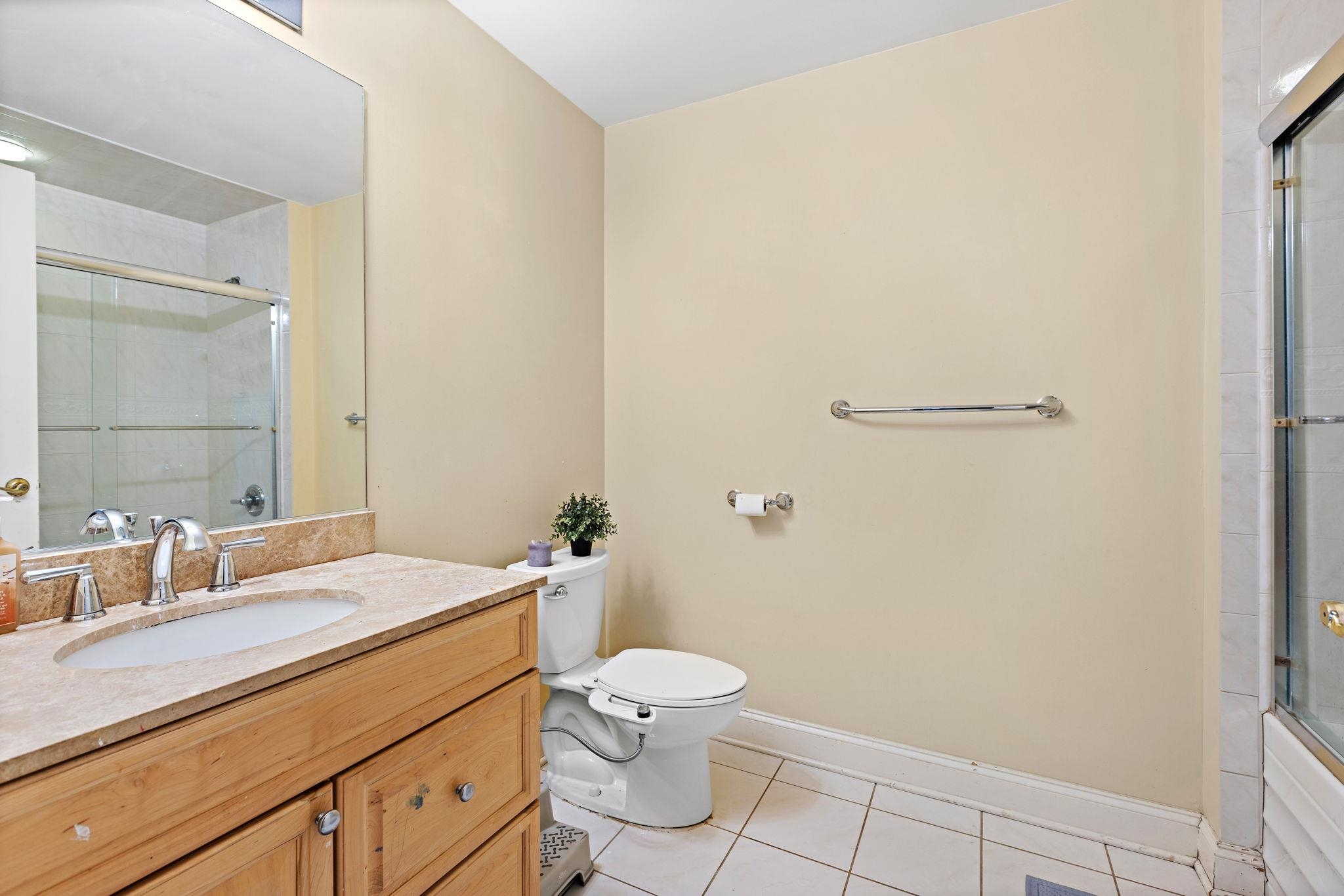 311 Washington Street, Unit 9C Jersey City, NJ 07302 - Photo 13 of 17 a bathroom with a granite countertop sink mirror vanity and toilet