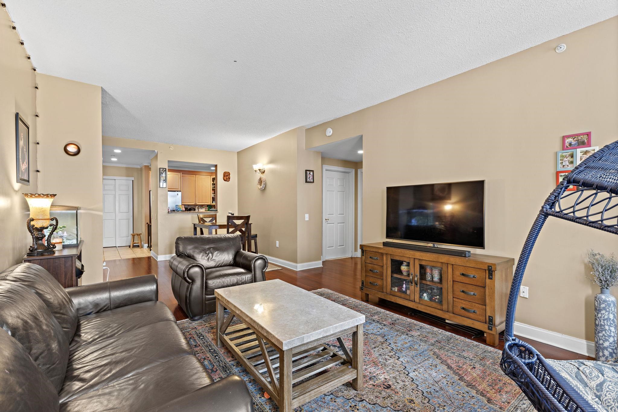 311 Washington Street, Unit 9C Jersey City, NJ 07302 - Photo 2 of 17 a living room with furniture and a flat screen tv