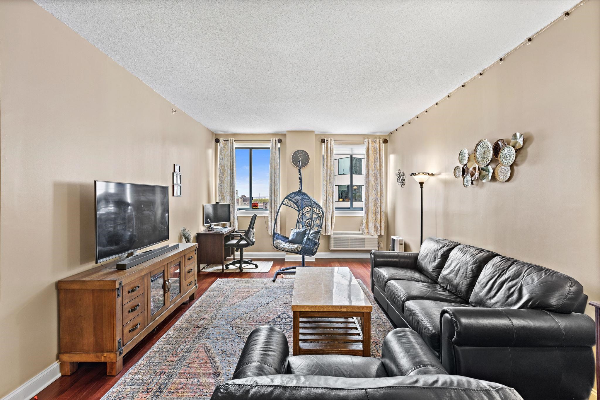 311 Washington Street, Unit 9C Jersey City, NJ 07302 - Photo 3 of 17 a living room with furniture and a flat screen tv