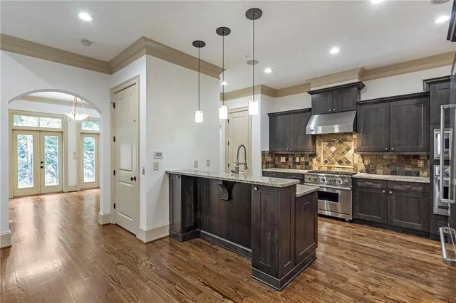 a kitchen with stainless steel appliances granite countertop wooden floors and sink