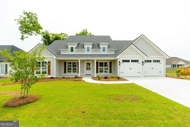 a front view of house with yard outdoor seating and garage