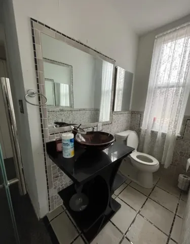 a bathroom with a granite countertop sink a mirror a vanity and shower
