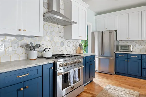 a kitchen with stainless steel appliances granite countertop a stove a refrigerator and a cabinets