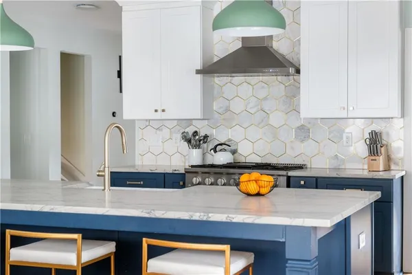 a kitchen with stainless steel appliances granite countertop a stove top oven a sink dishwasher and a refrigerator with wooden floor