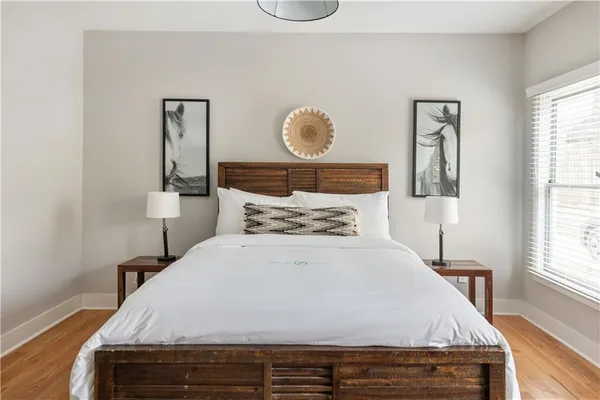 a bedroom with a bed and painting on the wall