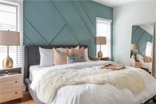 a bedroom with a bed and a painting on the wall