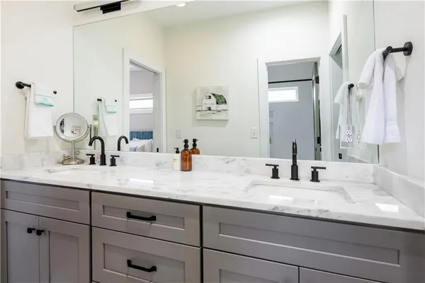 a bathroom with a granite countertop toilet sink and mirror