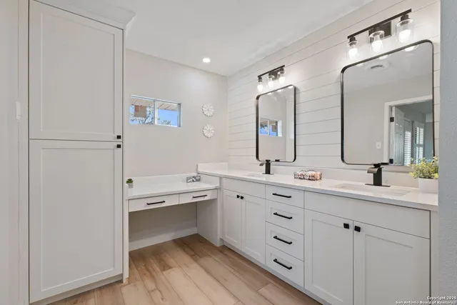 a spacious bathroom with a double vanity sink a mirror and a bathtub