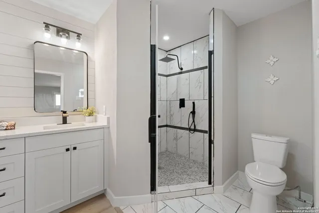 a bathroom with a toilet a sink and glass door