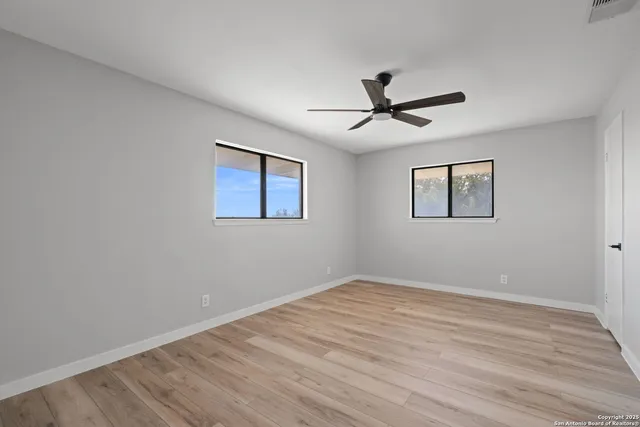 a view of a room with wooden floor and a ceiling fan