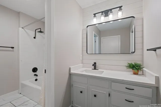 a bathroom with a double vanity sink mirror and bathtub