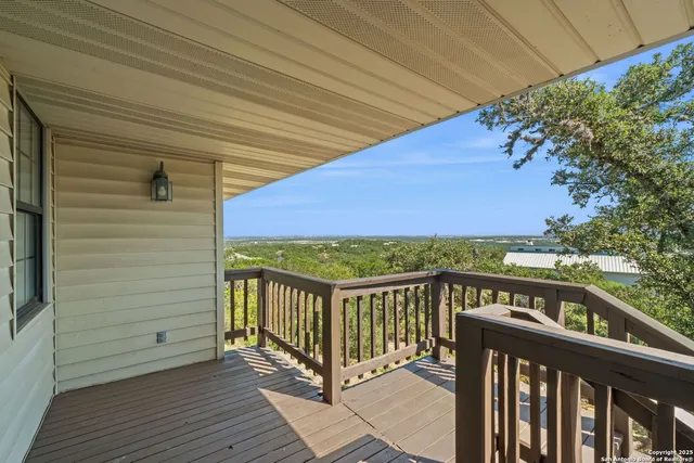 a view of a balcony with wooden floor and fence