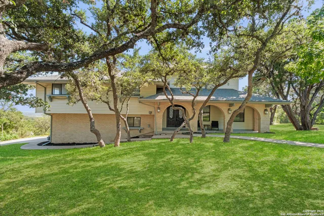 a white house that has a tree in front of it