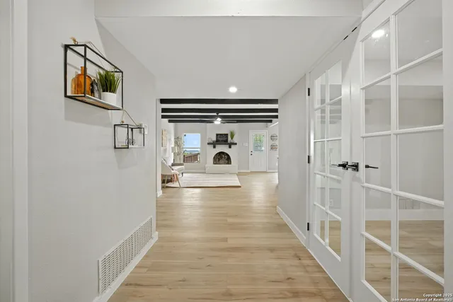a view of a hallway with wooden floor and windows