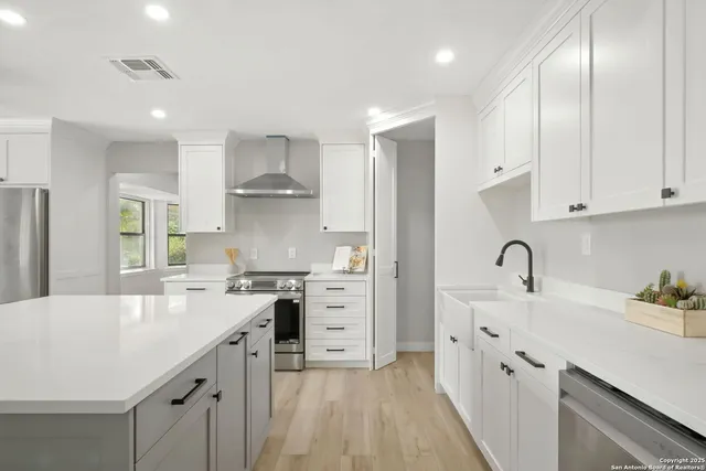a kitchen with white cabinets stainless steel appliances and sink