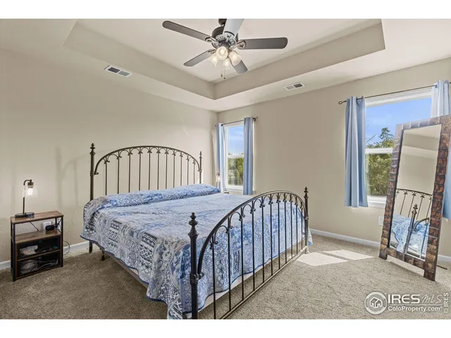 a bedroom with a bed window and a chandelier