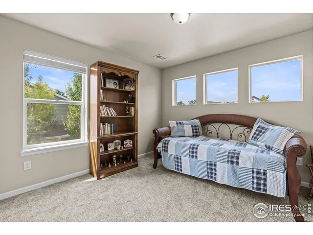 a large white bed sitting in a room next to a window