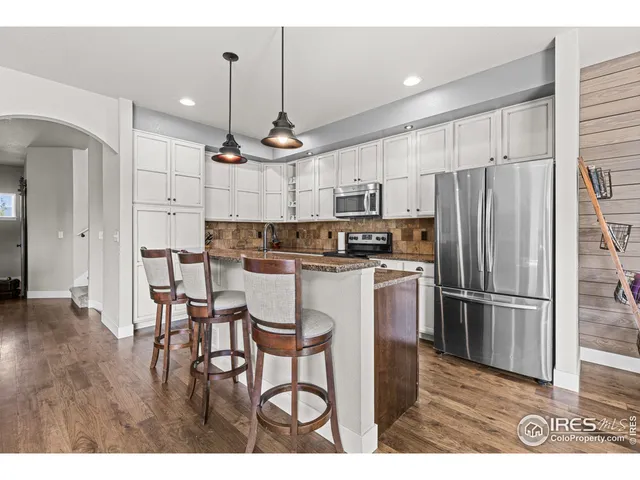 a kitchen with kitchen island granite countertop a refrigerator stove microwave and cabinets