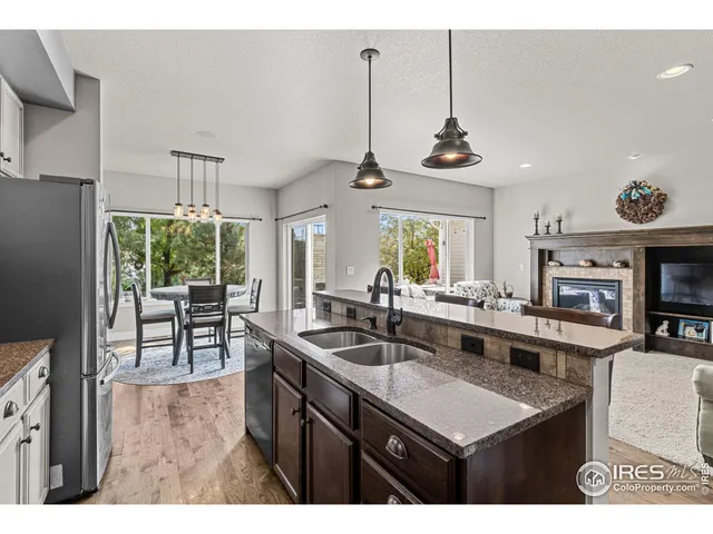 a kitchen with kitchen island granite countertop a sink a counter top space appliances and cabinets