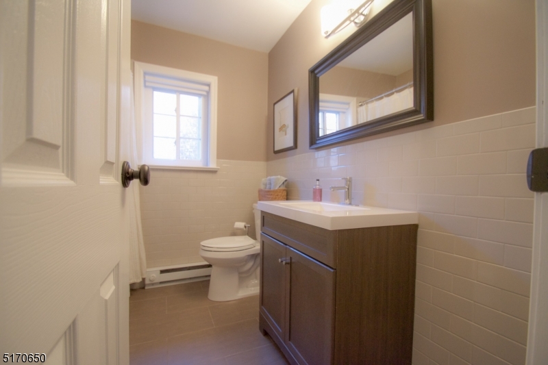 27 Corsa Terrace Ridgewood, NJ 07450 - Photo 10 of 10 a bathroom with a toilet sink and mirror