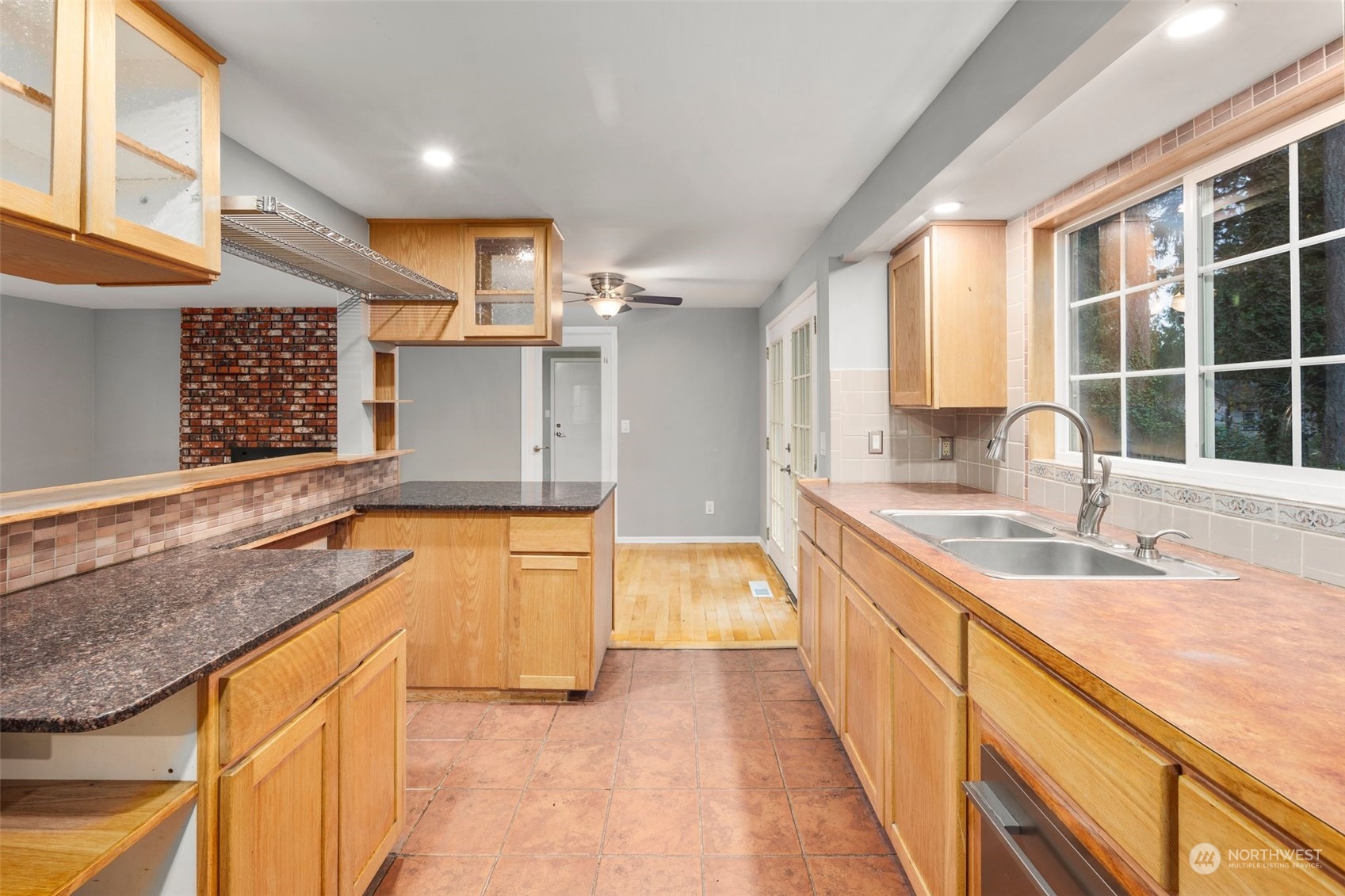 15832 Southeast 144th Street Renton, WA 98059 - Photo 17 of 40 a large kitchen with granite countertop a sink and a large window