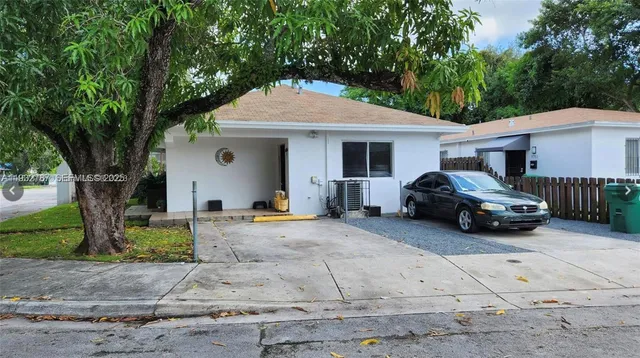 a front view of a house with cars parked