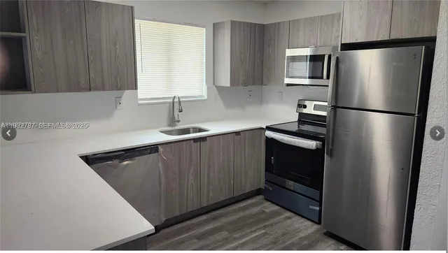 a kitchen with a refrigerator sink and cabinets