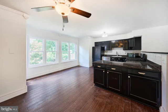 a kitchen with stainless steel appliances wooden cabinets and wooden floor