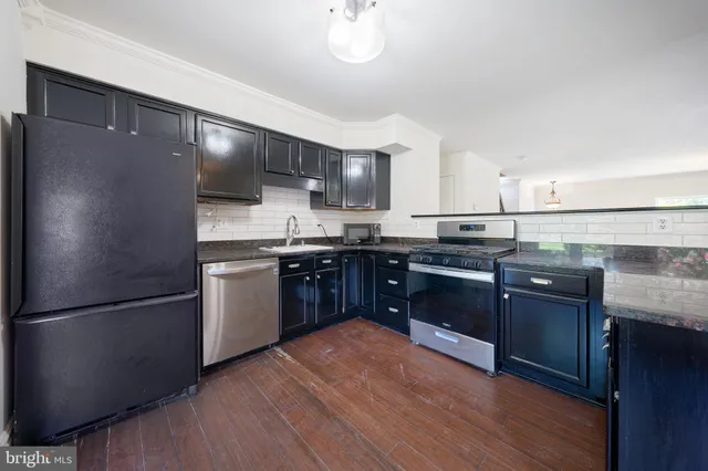 a kitchen with stainless steel appliances granite countertop a sink stove and cabinets