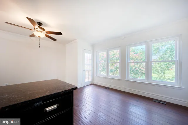 a kitchen with stainless steel appliances kitchen island wooden floors and refrigerator