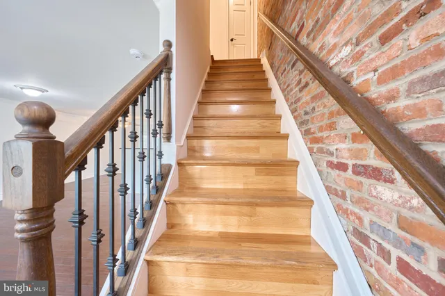 an empty room with wooden floor cabinet and windows