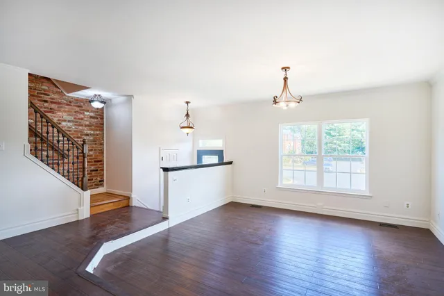a view of a kitchen with wooden floor and a window