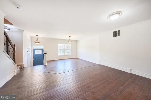 a view of a livingroom with wooden floor and a window