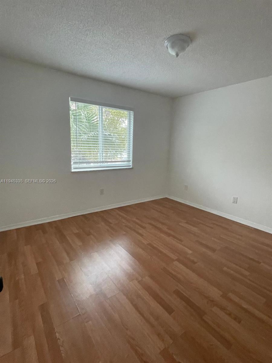 14830 Naranja Lakes Boulevard, Unit A2Q Homestead, FL 33032 - Photo 5 of 8 an empty room with wooden floor and windows
