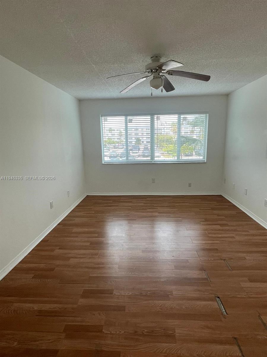 14830 Naranja Lakes Boulevard, Unit A2Q Homestead, FL 33032 - Photo 7 of 8 an empty room with wooden floor chandelier fan and windows