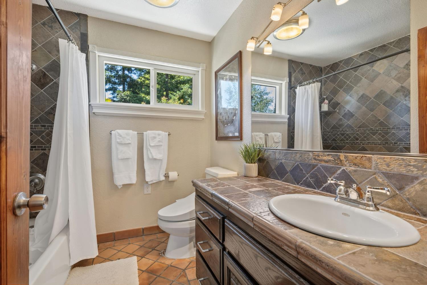 4206 Zephyr Way Sacramento, CA 95821 - Photo 29 of 45 a bathroom with a granite countertop sink a toilet and a mirror