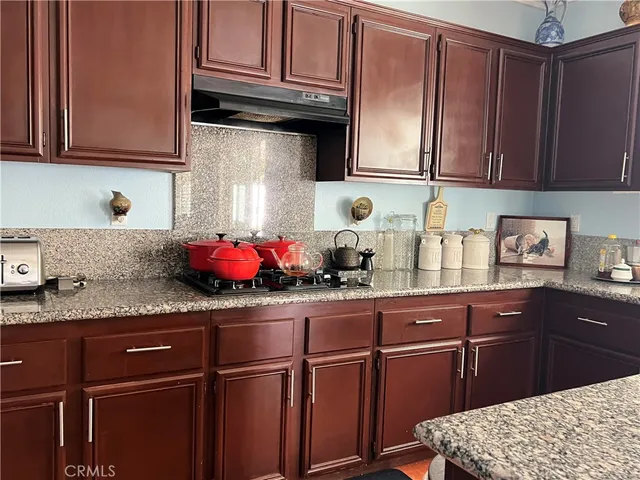 a kitchen with granite countertop wooden cabinets and sink