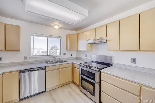 a kitchen with cabinets appliances a sink and a window