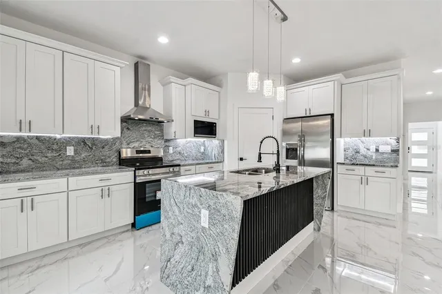 a kitchen with stainless steel appliances granite countertop a sink stove and refrigerator