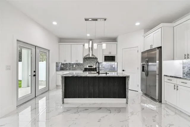 a kitchen with stainless steel appliances a stove a refrigerator and a sink