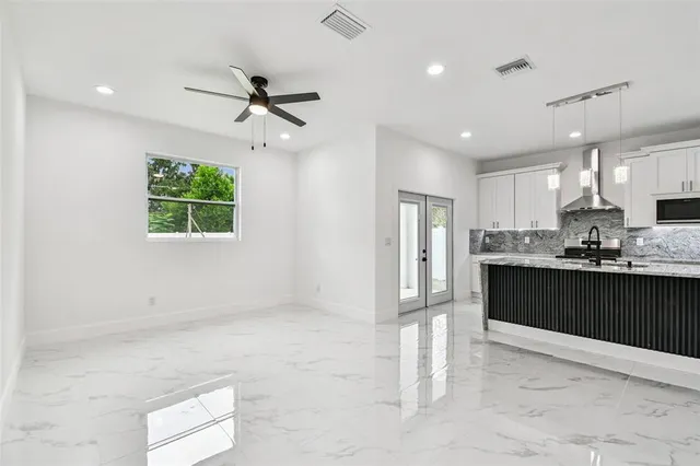 a living room with stainless steel appliances kitchen island granite countertop furniture a window and a kitchen view